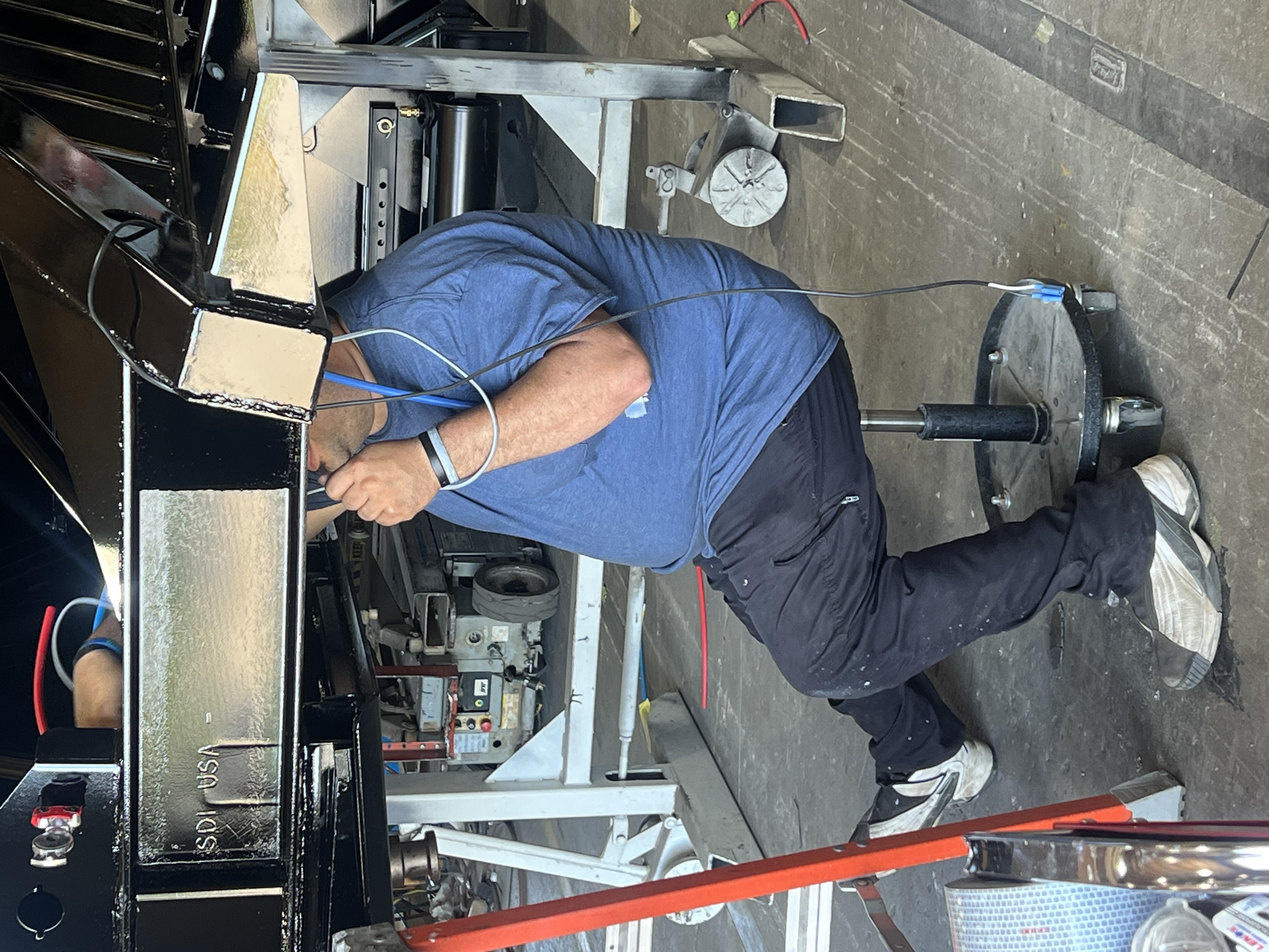 man working on what appears to be a vehicle chassis or large metal structure