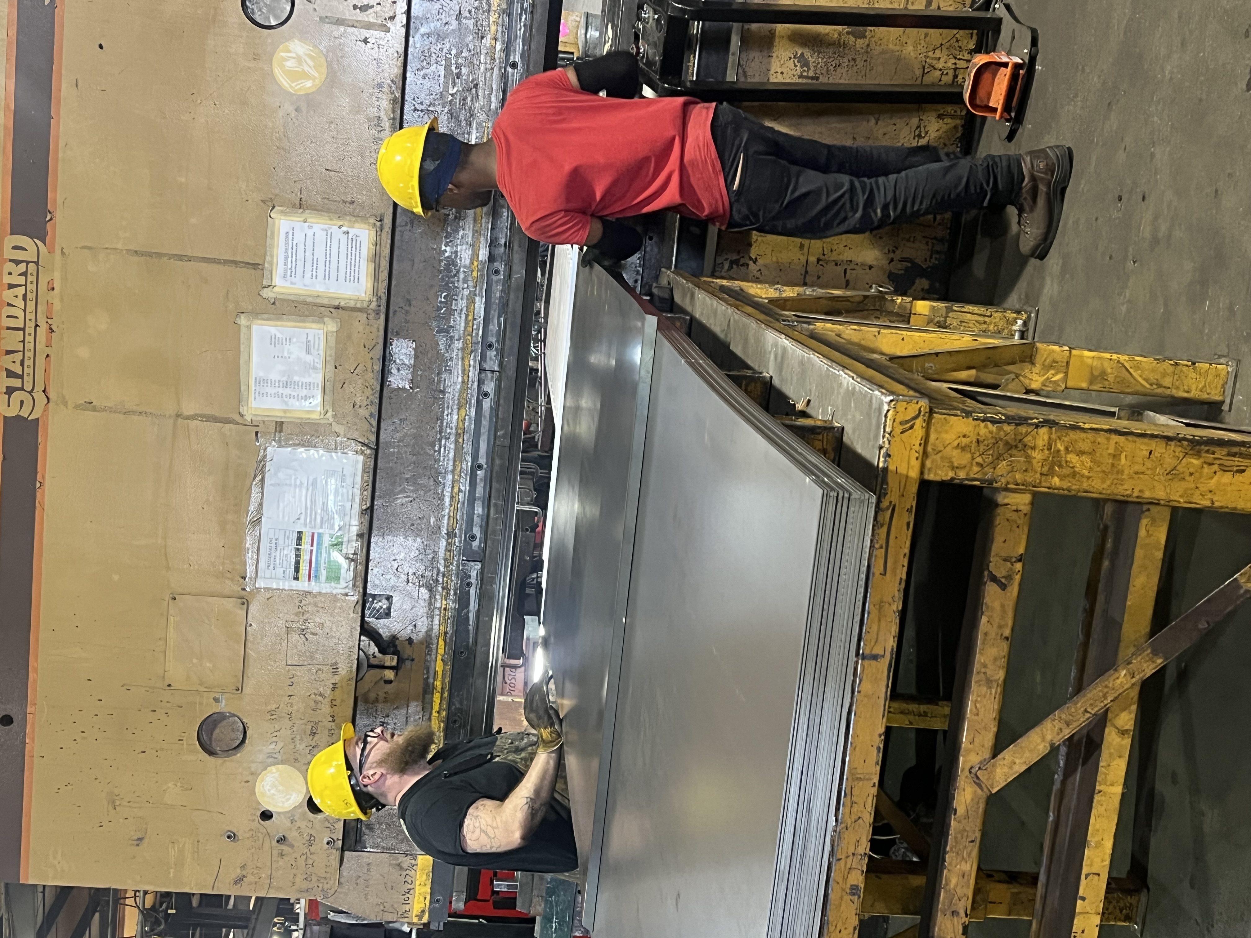 two individuals working with large sheets of meta