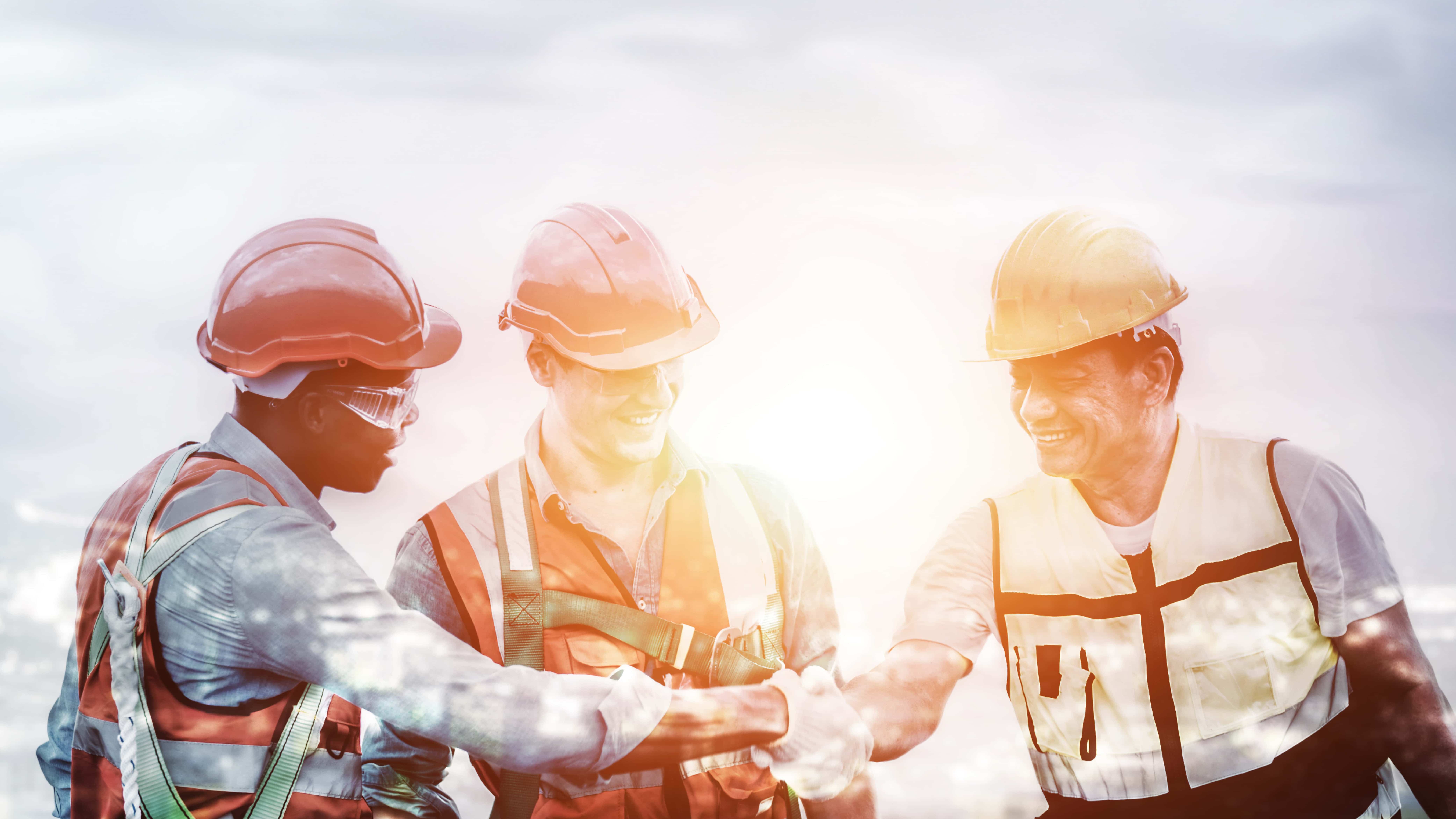 Image of 3 construction workers shaking hands